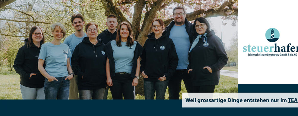 Gruppenfoto des Teams vom Steuerhafen Lübeck mit Logo und dem Slogan „Weil großartige Dinge entstehen nur im TEAM.“